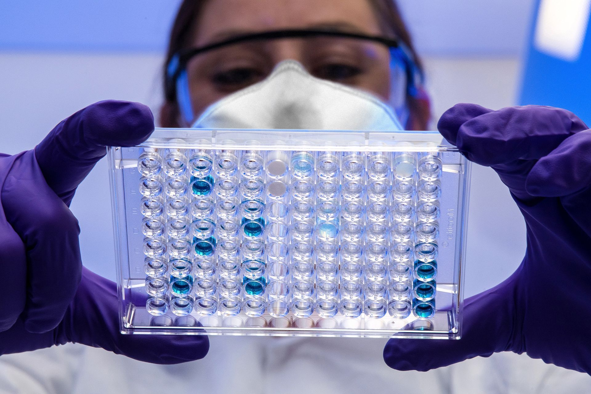Scientist using a microscope in a biomedical research laboratory